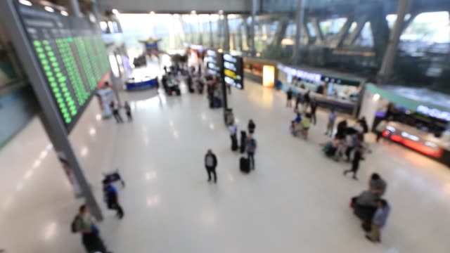 Draufsicht-der-abstrakten-verwischen-Flughafen-terminal-mit-Pendler-Menschenmenge-und-Passagier-zu-Fuß-wenn-verfolgen-Sie-ankommen-oder-abfliegen-Flüge,-verschwommene-geschäftigen-Flughafen-Terminal-Filmmaterial-Konzept.-Volle-HD1920x1080