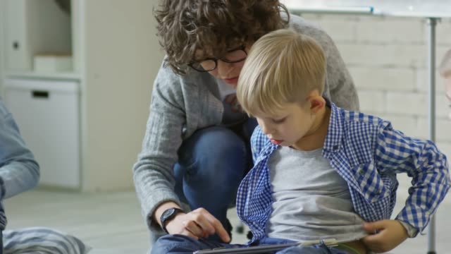Maestra,-ayudar-a-los-niños-a-usar-la-tableta-Digital