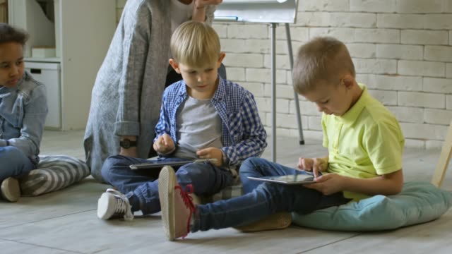 Kinder-lernen-digitale-Tablets-mit-Lehrerin