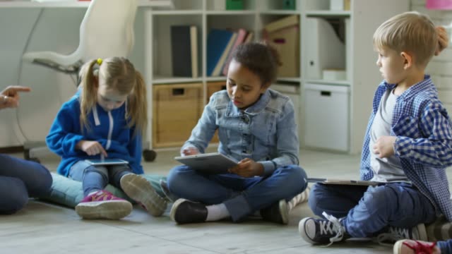 Niños-pequeños-aprender-tabletas-en-jardín-de-infancia