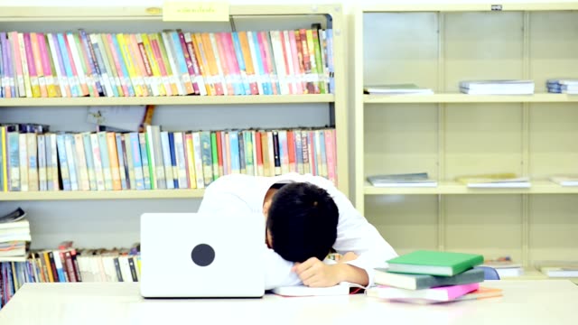 Estudio-duro-en-biblioteca.-Estudio-de-niño-chino-duro-en-biblioteca.-Caída-a-dormir.