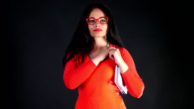 Porträt-von-sexy-Brünette-Frau-mit-roten-Lippen,-im-roten-Kleid-und-roten-Brille,-mit-weißen-kleinen-Handtasche,-bewegt-sie-sich-erotisch-und-verspielt,-sexuell-Blick-in-die-Kamera,-posiert-im-studio