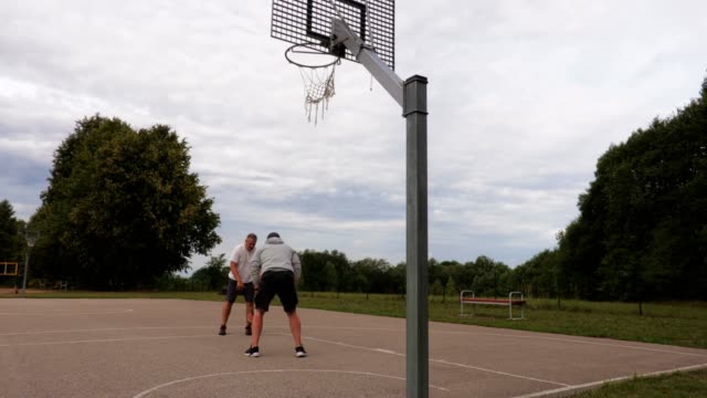 Zwei-Männer-spielen-Basketball-im-freien