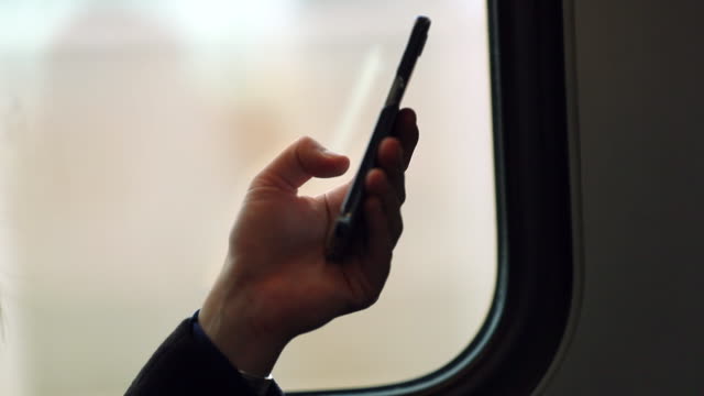 Hand-holding-up-cellphone-while-on-commute-from-work