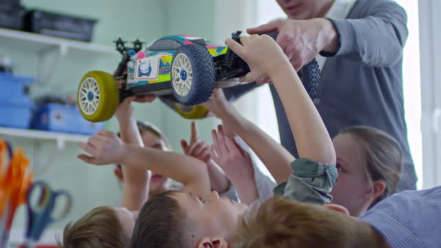 Kinder-untersuchen-Spielzeugauto-in-der-Schule