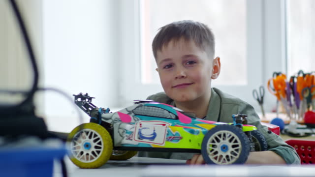 Junge-posiert-mit-Spielzeug-Auto-Modell