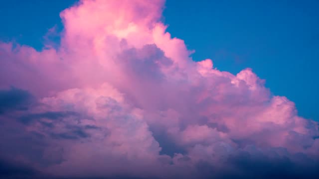 Schönen-blauen-Himmel-und-fließende-Welle-der-riesige-weiße-und-violette-Cumulus-Wolken.-Blauer-Himmel-mit-Bewegung-flauschigen-Wolken,-die-Farbe-von-weiß-bis-lila-und-blau-ändern.-Wolkengebilde-Bewölkter-Himmel-mit-Sonnenlicht.
