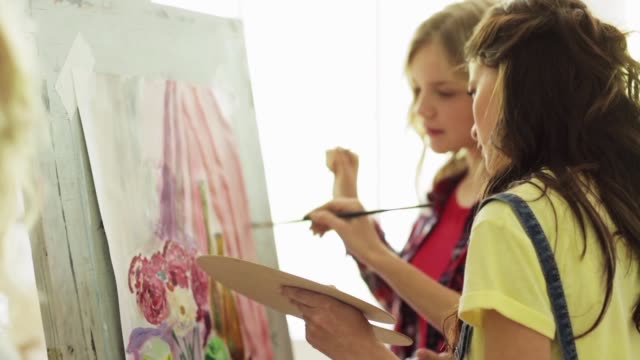 estudiantes-con-caballetes-de-pintura-en-la-escuela-de-arte