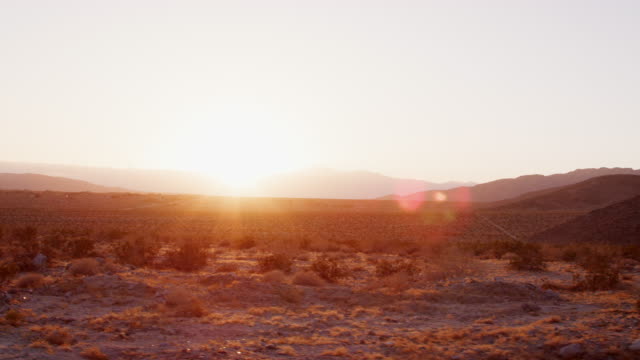 Desert-landscape-at-sunset-seen-from-moving-vehicle