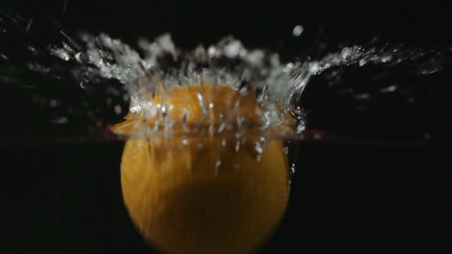 Naranja-cayendo-en-cámara-lenta-de-agua