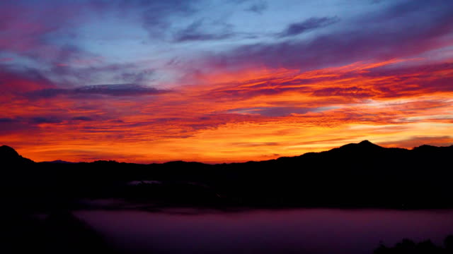 Zeitraffer-des-Sonnenaufgangs-im-Morgengrauen-mit-Berg--und-nebligen-Landschaft