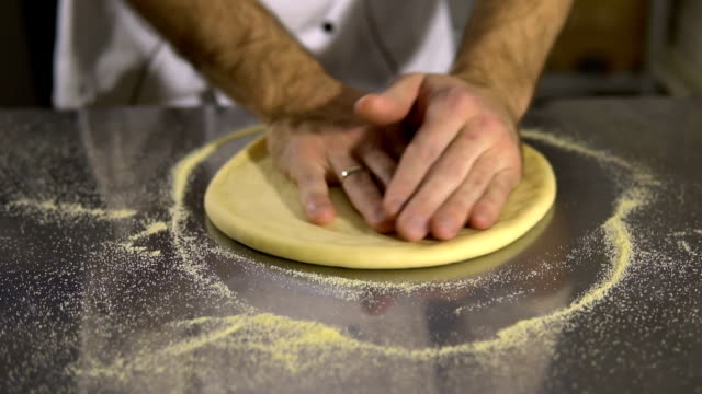Cocinar-en-la-cocina-preparando-la-masa-de-pizza.-Un-hombre-prepara-pasteles
