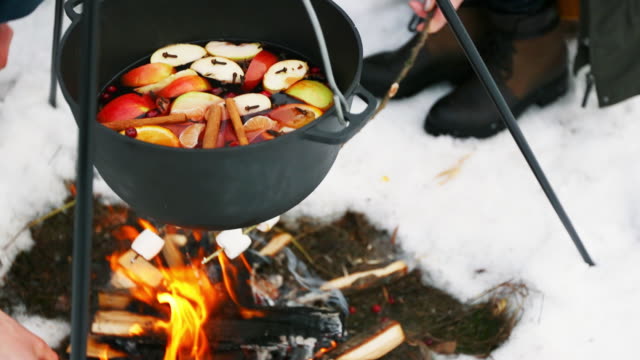 Cocinar-el-vino-caliente-en-la-hoguera-en-el-bosque-de-invierno.