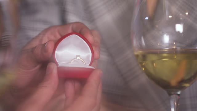 Hombre-haciendo-la-propuesta-de-matrimonio-a-mujer-en-restaurante-Closeup