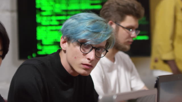 Young-Man-in-Glasses-Coding-on-Laptop