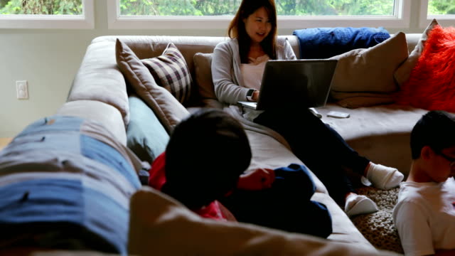 Mother-and-son-using-laptop-in-living-room-4k