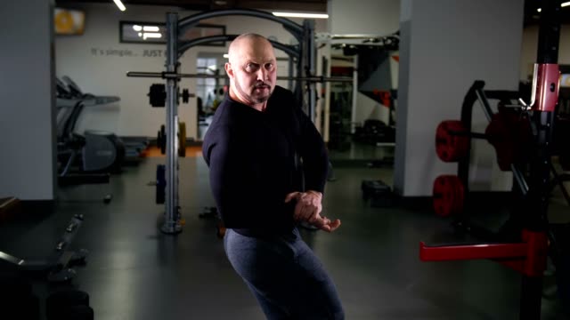 Erwachsenen-Bodybuilder-zeigt-Muskeln-auf-4K-Kamera-Slow-Mo