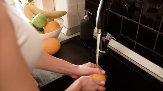 Waschen-Obst-mit-sauberem-Wasser-In-Küche-Nahaufnahme
