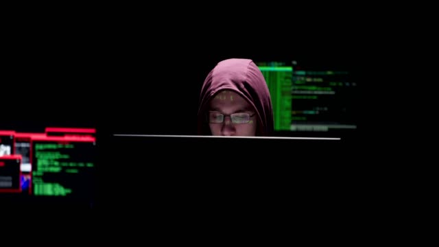 Man-with-a-hoodie-siting-in-the-data-computer-room-with-data-on-his-face