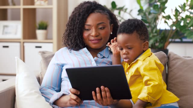 madre-usando-Tablet-PC-con-bebé-hijo-en-casa