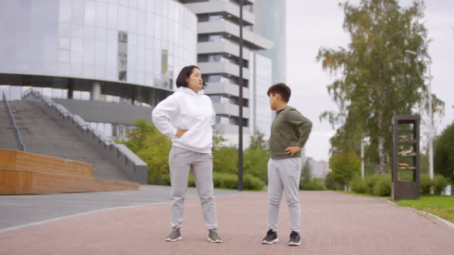 Asian-Mother-and-Son-Training-Outdoors-in-City-Center