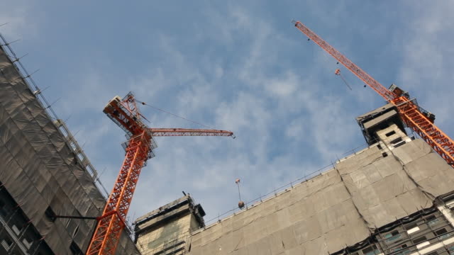 Construction-site-working-with-machine-to-build-high-tower-on-clear-sky