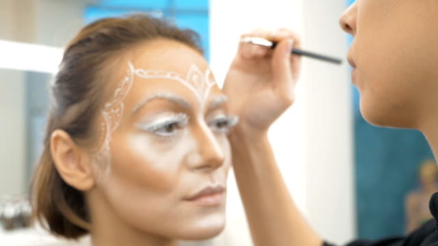Make-up-Artist-zieht-Körperkunst-auf-dem-Modell.-Vorbereitung-für-eine-Foto-session