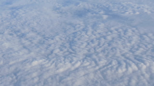 Beautiful-air-clouds-float-above-ground.-Aerial-view-from-the-airplane
