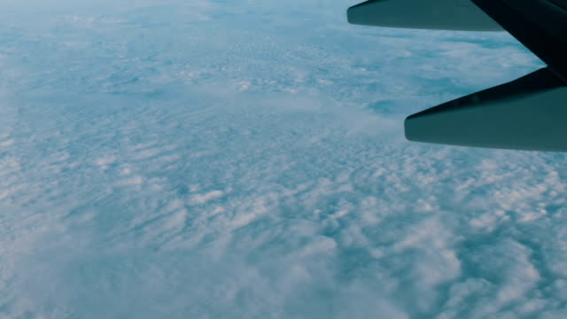 Blick-auf-die-Flügel-eines-Flugzeuges-im-Flug-über-schöne-Luft-Wolken