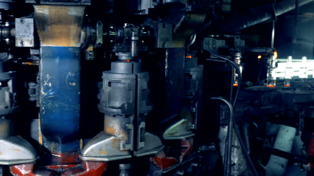 Factory-machine-melts-out-bottles,-speed-filming.