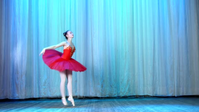 ballet-rehearsal,-on-the-stage-of-the-old-theater-hall.-Young-ballerina-in-red-ballet-tutu-and-pointe-shoes,-dances-elegantly-certain-ballet-motion,-pas-courru-,-tour-fouette