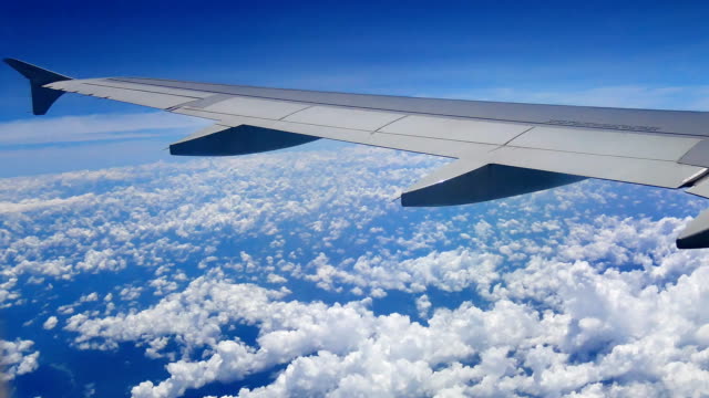 Video-Blick-aus-dem-Flugzeug-Fenster-durch-die-Flügel-und-Motor-während-des-Fluges-durch-die-Wolke-und-Bluesky-im-Transportwesen-oder-Reisen-Sie-Konzept.