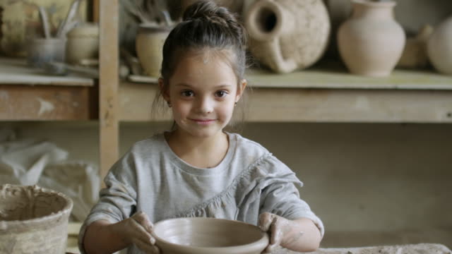 Niedliche-kleine-Mädchen-machen-Keramik-und-posiert
