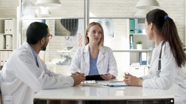 Female-Doctor-Talking-to-Colleagues-at-Meeting
