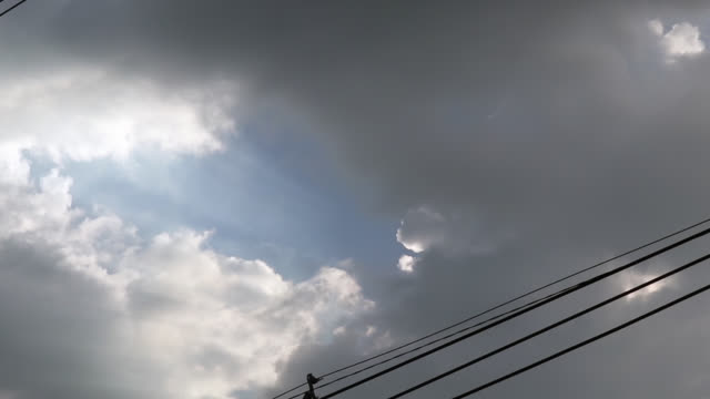 Gray-bedeckt-Wolken-am-blauen-Himmel-vor-Regen-oder-Sturm.-Stromleitungen-gehen-durch-den-Himmel.