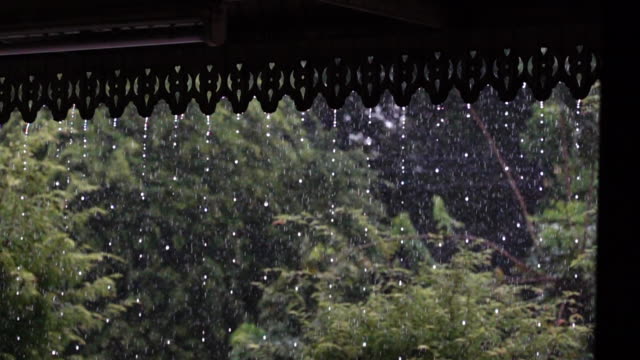 Starkregen-am-Wasser-mit-high-Speed-Kamera,-fällt-vom-Dach,-nasses-Wetter,-flüssige-Abstraktheit-Closeup-Video.-Regentropfen-fallen-Saison.