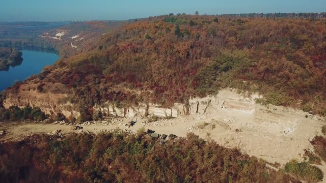 View-on-the-work-of-equipment-in-the-sand-quarry-on-the-background-of-the-forest-near-the-river.