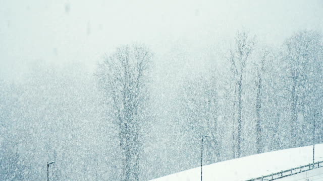 Large-snow-flakes-are-falling-from-the-sky,-very-large-snow-falls-by-a-wall,-slow-motion