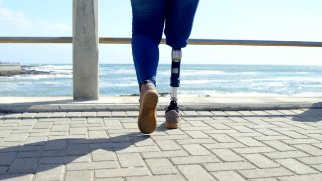 Low-section-of-disabled-woman-walking-on-promenade-near-railing-4k