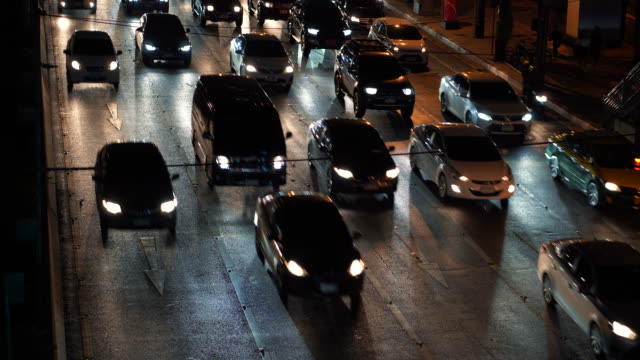 Verkehr-während-der-Hauptverkehrszeit,-Fahrzeuge-fahren-auf-mehrere-spurige-Straße-in-dunklen-Zeit