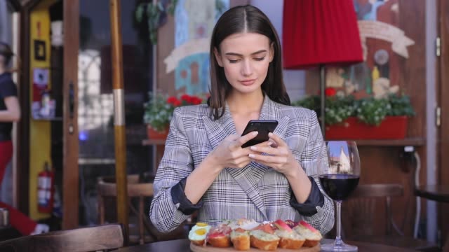Beautiful-Woman-Taking-Food-Photos-On-Mobile-Phone-At-Restaurant