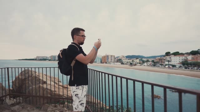 Männliche-Touristen-schießen-Strand-auf-Smartphone.