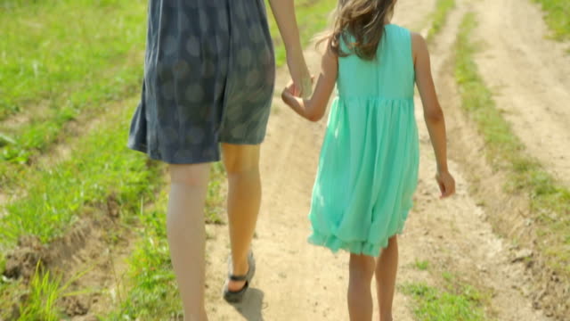 Madre-y-su-hija-caminando-por-un-camino-rural