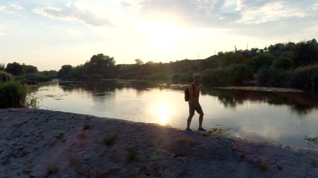 Young-man-walking-on-riverbank