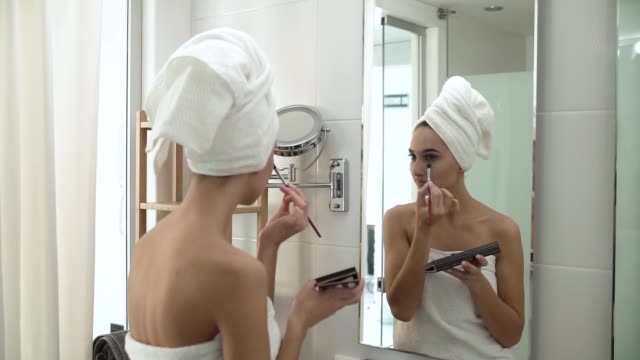 Makeup.-Woman-Applying-Eyeshadows-And-Looking-At-Mirror