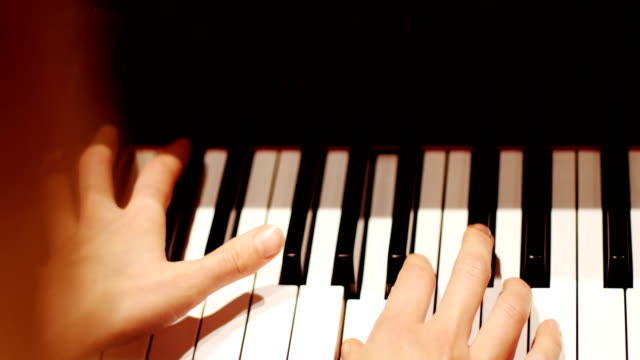 Close-up-of-woman-playing-a-piano