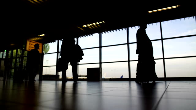 Silhouetten-von-Menschen-mit-Koffern-Umzug-in-Abflughalle-am-Flughafen