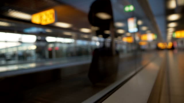 Passagier-mit-Koffer-bewegen-auf-Rolltreppe-am-Flughafen,-terminal-Halle