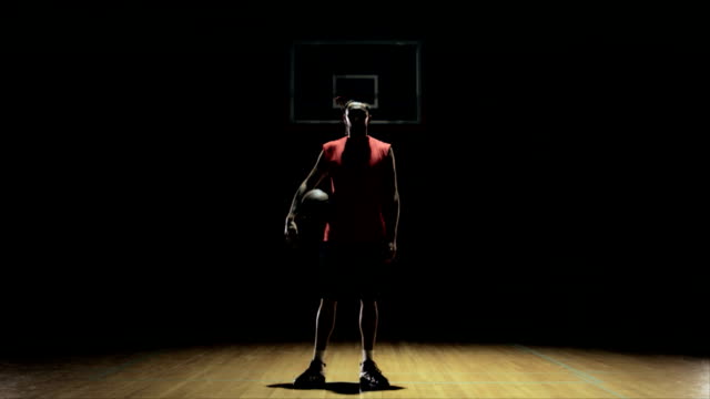 Eine-Basketballspieler-befasst-sich-mit-Kamera,-wirft-Ball-und-Ausfahrten.
