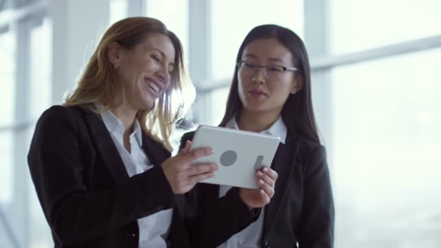 Cheerful-Businesswoman-Looking-at-Tablet